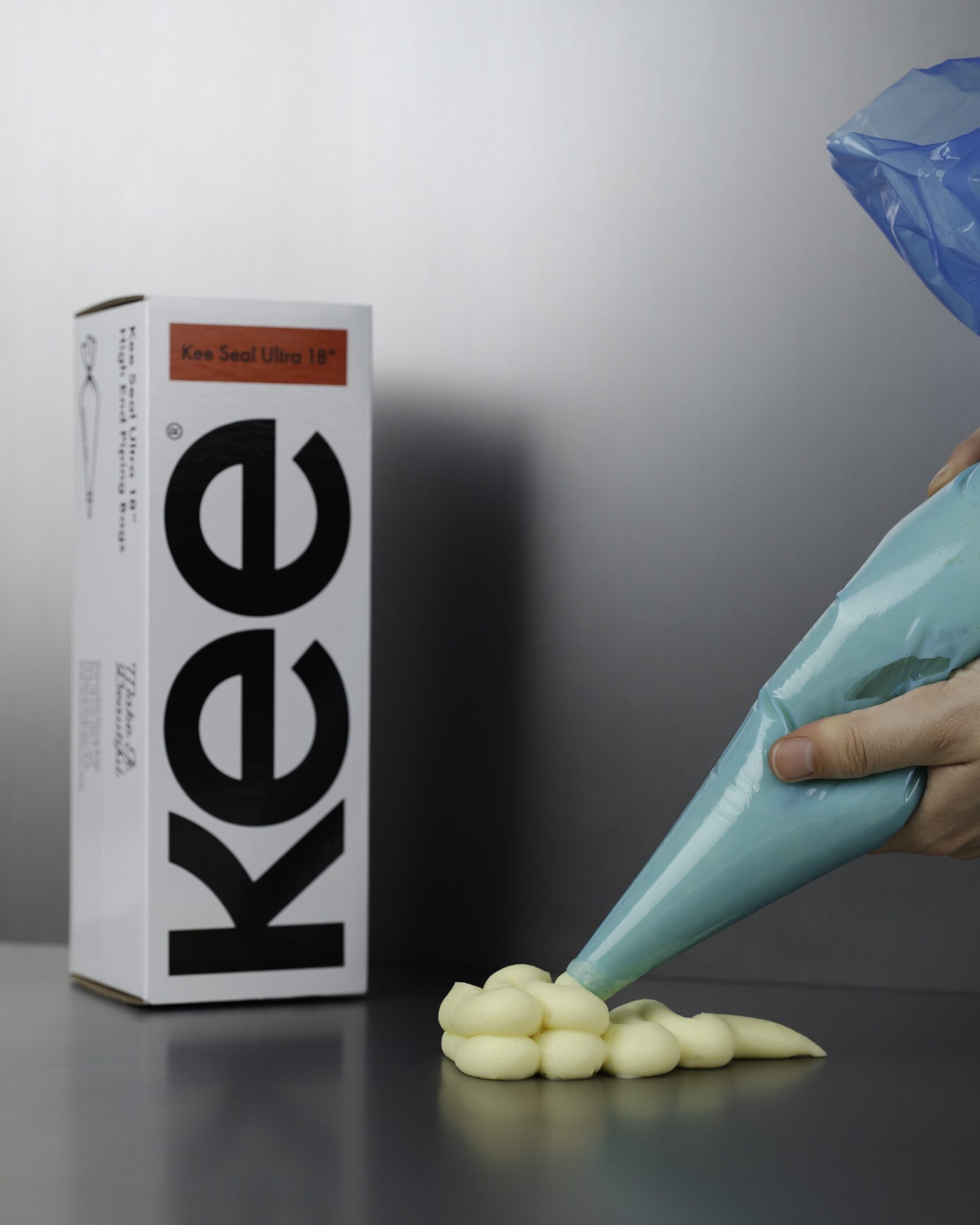 Kee-Seal Ultra piping bag being used Infront of the kee-seal ultra packaging